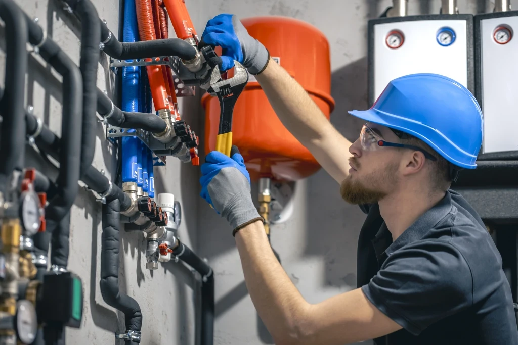 man-installs-heating-system-house-checks-pipes-with-wrench.jpg